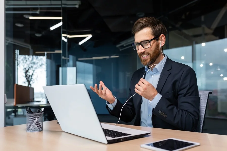 An investor talking through a decision on a video call at a laptop.