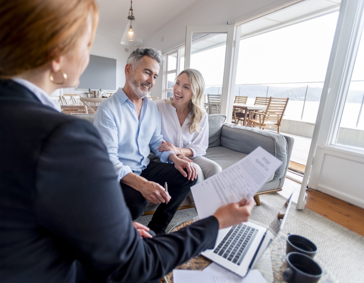An advisor reviewing tax documents with clients at a bright waterfront home