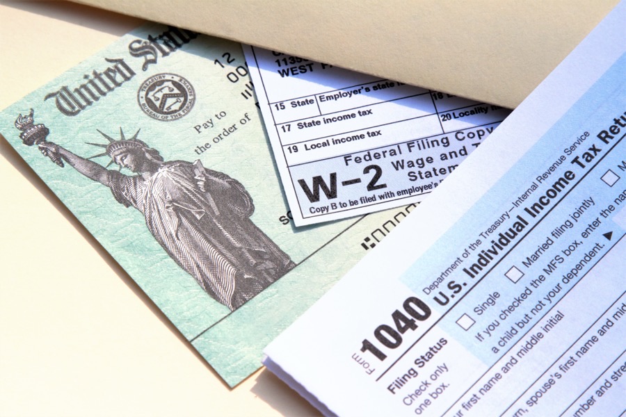 U.S. tax forms — a 1040, a W-2, and a U.S. Treasury refund check