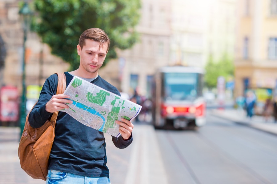 An American reading a city map while getting oriented in a new country abroad